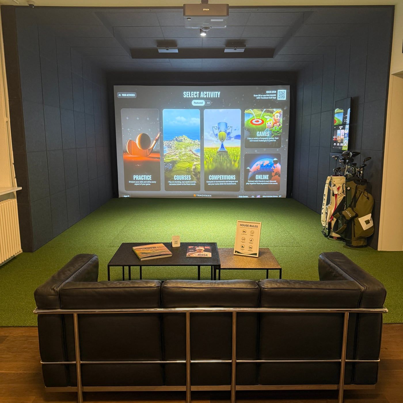 Blick über das Loungesofa auf den TrackMan Simulator und die Abschlagfläche